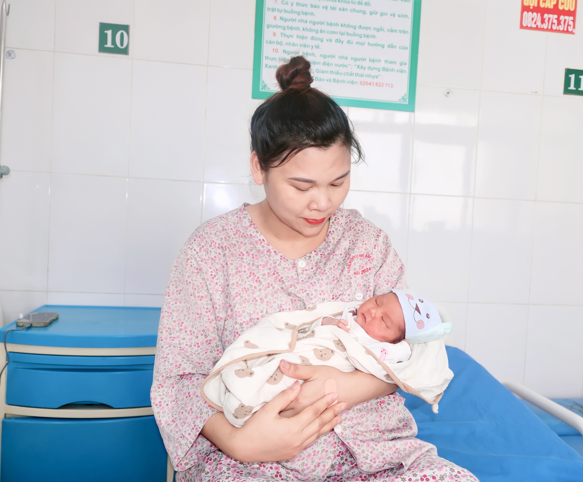 Chị Bùi Thị Nhung hạnh phúc ngắm nhìn con yêu ngủ ngoan trong vòng tay